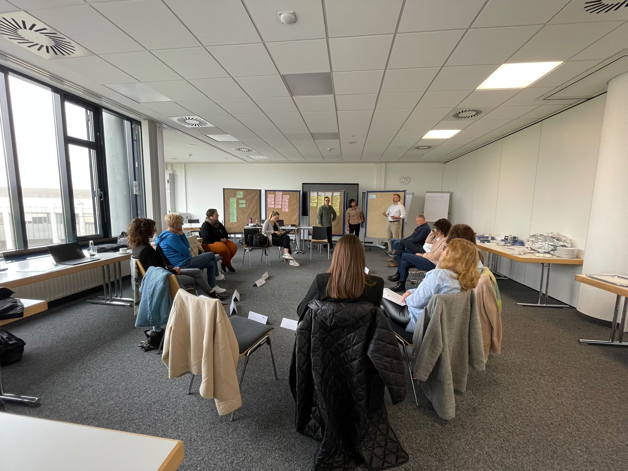 Workshop im Seminarraum, Teilnehmende sitzen im Halbkreis