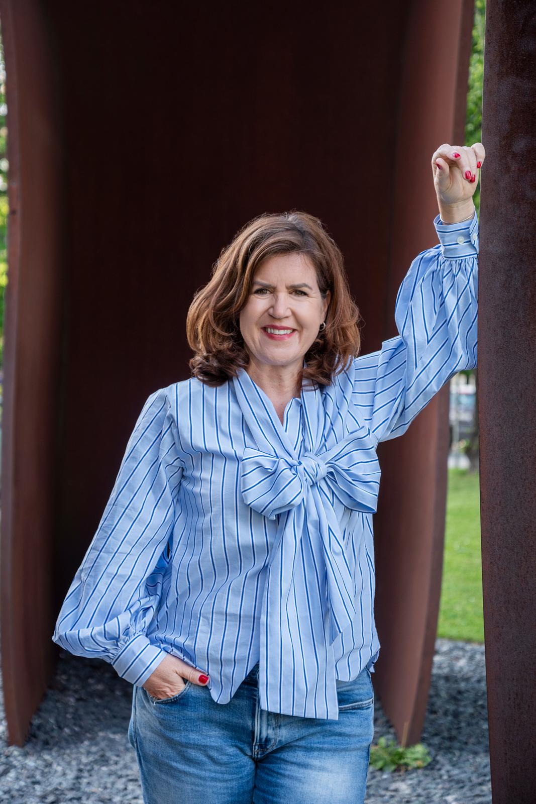 Tanja Almanstötter – stehend im Freien, gestreifte Bluse